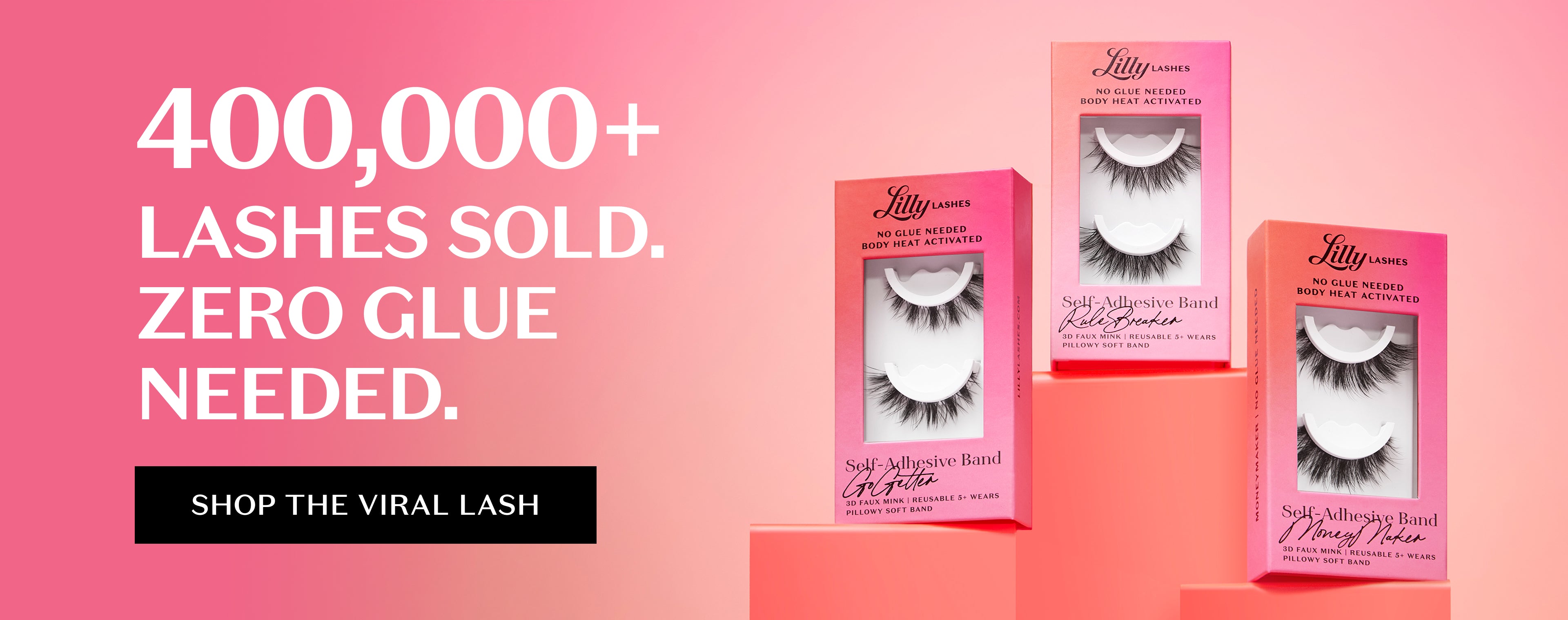 Pink gradient background with bold white text reading ‘400,000+ Lashes Sold. Zero Glue Needed.’ Black button below says ‘Shop the Viral Lash.’ Three Lilly Lashes Self-Adhesive Band lash boxes displayed on pink podiums, featuring styles ‘Godiva,’ ‘Lash Breaker,’ and ‘Money Maker.